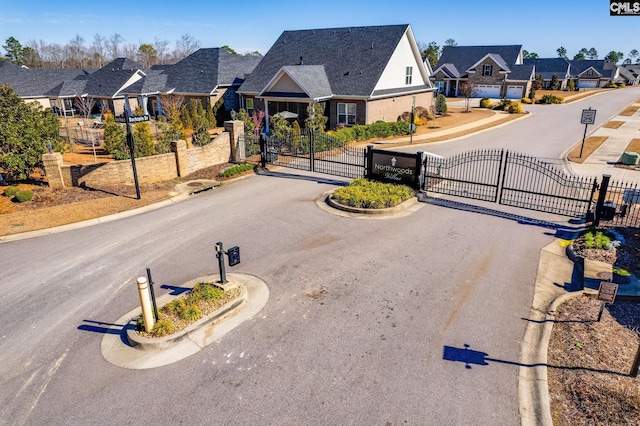 view of street with a residential view, a gate, and curbs