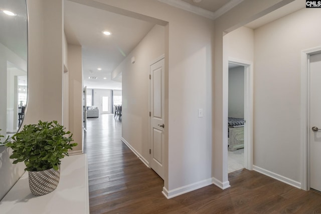 hall featuring dark wood-style floors, baseboards, ornamental molding, and recessed lighting