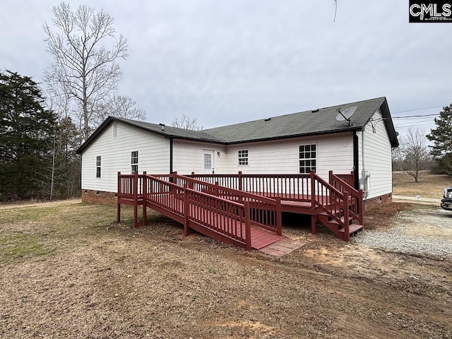 back of property with a shingled roof, crawl space, and a deck