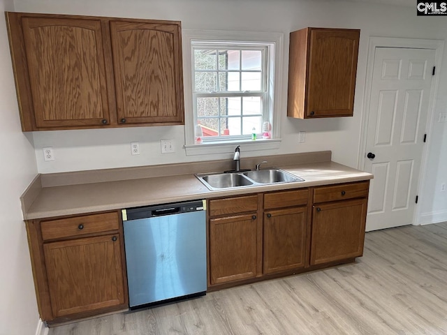 kitchen featuring light wood-style floors, light countertops, dishwasher, and a sink