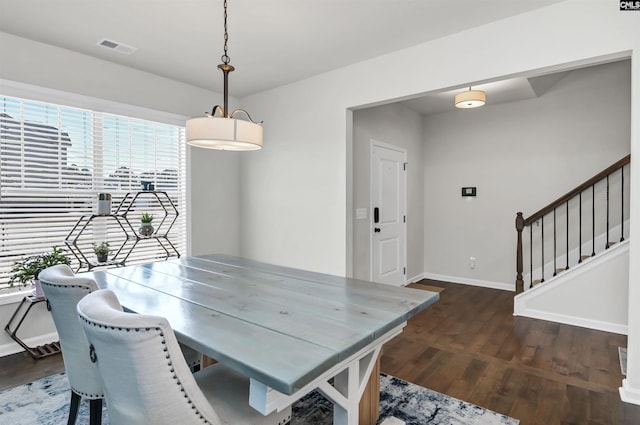 dining space with visible vents, stairs, baseboards, and dark wood finished floors