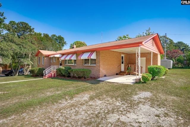 view of front of home with a carport, crawl space, brick siding, and a storage unit