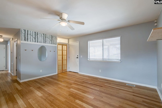 empty room with visible vents, light wood-style flooring, and baseboards