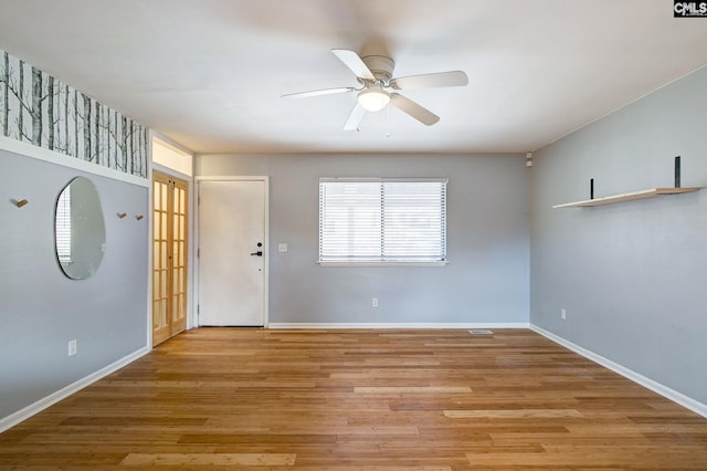 interior space featuring light wood-type flooring, baseboards, and a ceiling fan