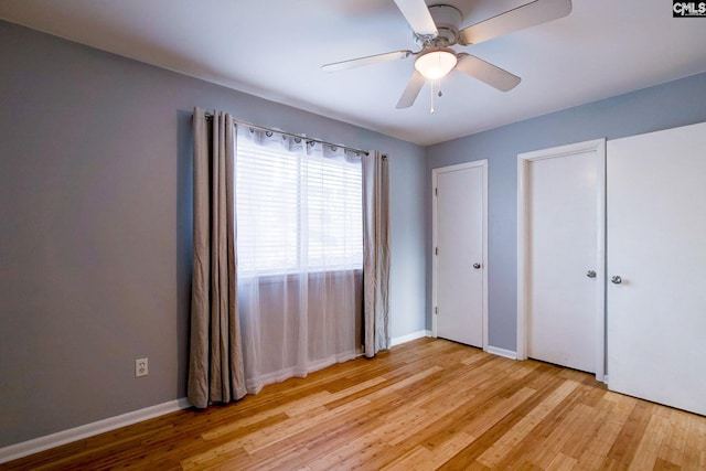 unfurnished bedroom with light wood-type flooring, baseboards, and a ceiling fan