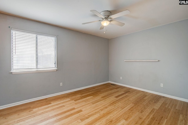 empty room featuring a ceiling fan, baseboards, and wood finished floors