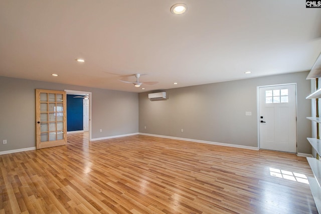 empty room featuring light wood-style floors, recessed lighting, an AC wall unit, and ceiling fan