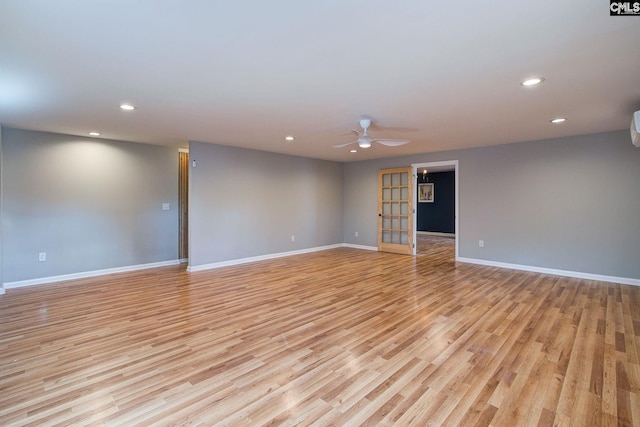 empty room featuring baseboards, light wood-type flooring, and recessed lighting