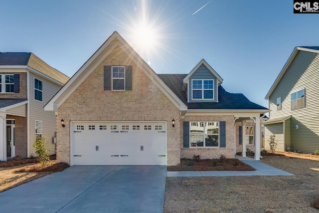 view of front of home with a garage, concrete driveway, and brick siding