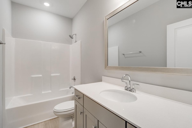 bathroom with shower / washtub combination, vanity, toilet, and wood finished floors