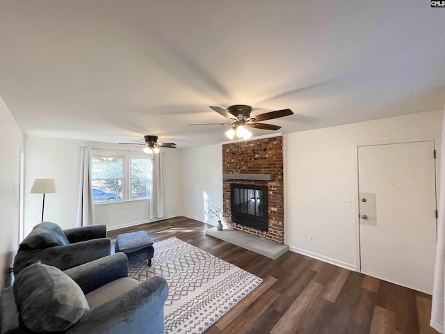 living area with a fireplace, baseboards, and wood finished floors