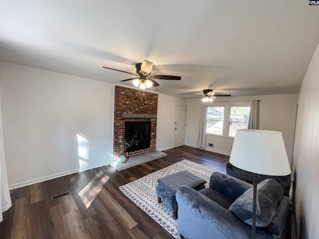 living room with a fireplace, wood finished floors, visible vents, and baseboards