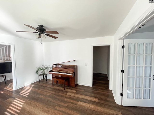 living area featuring dark wood finished floors, stairway, baseboards, and ceiling fan