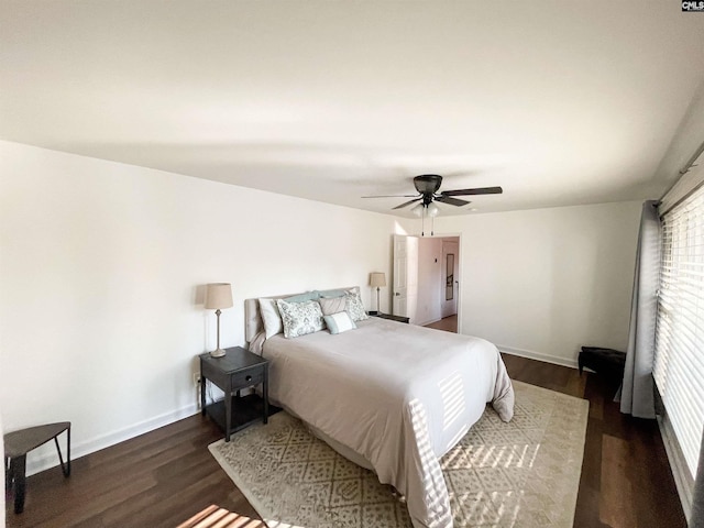 bedroom featuring ceiling fan, baseboards, and wood finished floors