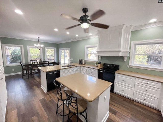 kitchen with light countertops, white cabinetry, a sink, a peninsula, and black appliances