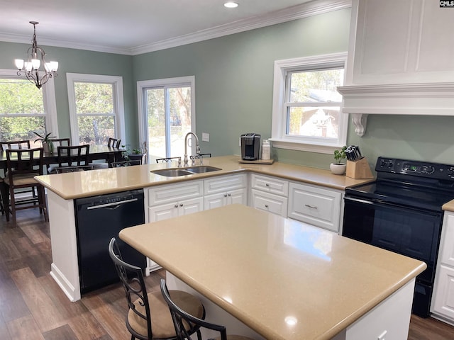 kitchen featuring black appliances, a peninsula, a sink, and white cabinets