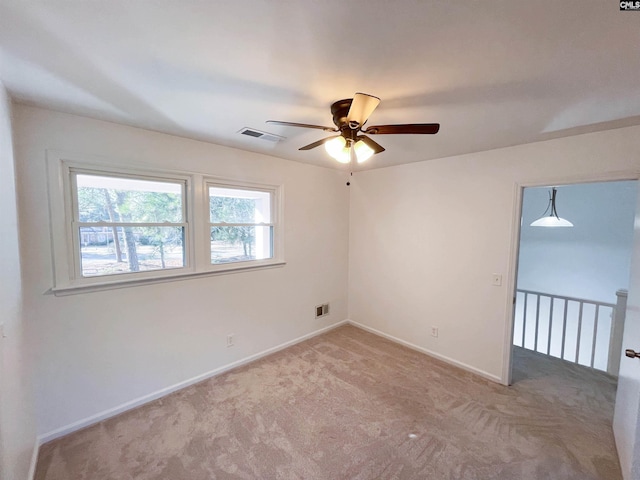 unfurnished room featuring carpet floors, baseboards, visible vents, and ceiling fan