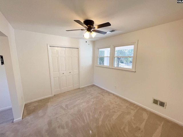 unfurnished bedroom featuring light carpet, baseboards, and visible vents