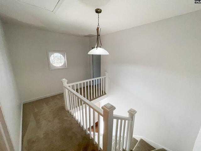 staircase featuring attic access, carpet, and baseboards