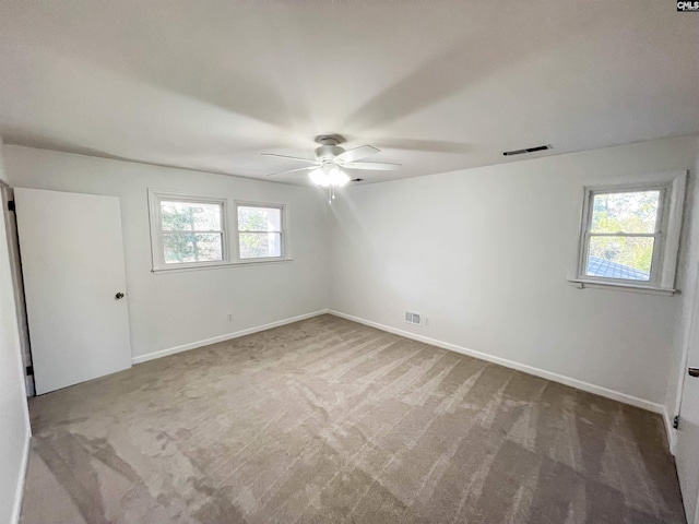 unfurnished bedroom with multiple windows, carpet flooring, visible vents, and baseboards