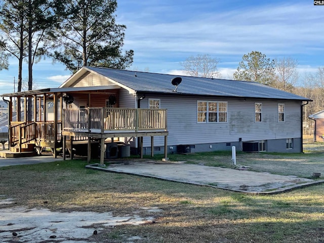 rear view of property featuring a deck, central AC, a yard, and driveway