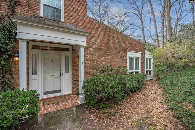 entrance to property featuring brick siding