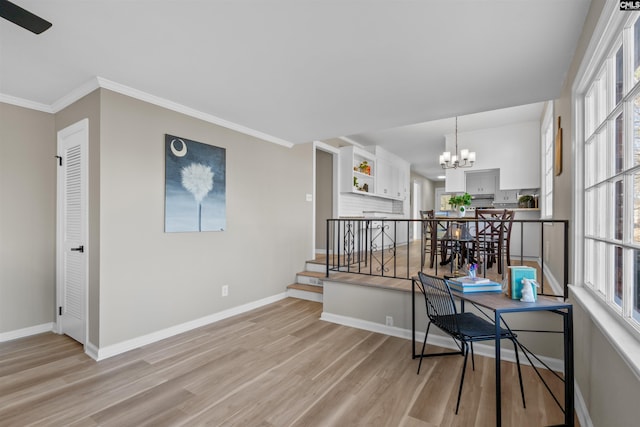 office area with baseboards, crown molding, light wood-type flooring, and an inviting chandelier