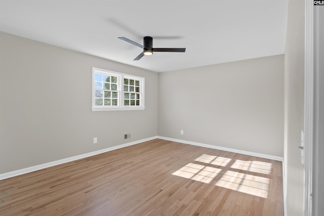 empty room featuring ceiling fan, light wood-type flooring, visible vents, and baseboards