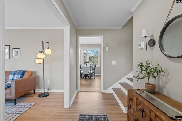 foyer featuring light wood-type flooring, baseboards, and ornamental molding