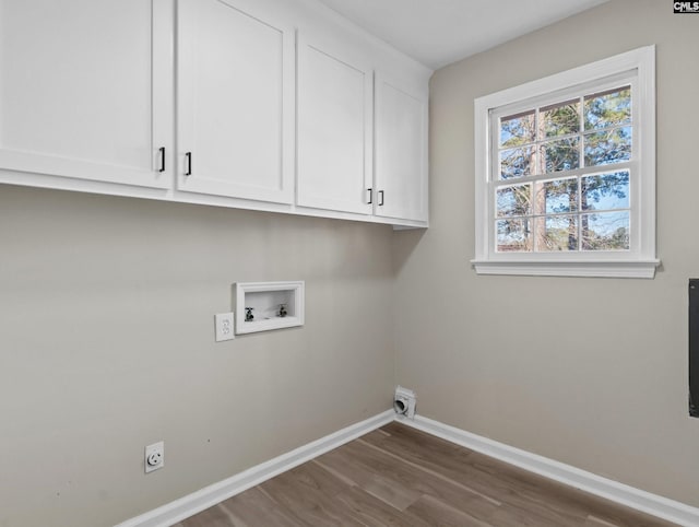 washroom featuring hookup for an electric dryer, washer hookup, baseboards, cabinet space, and dark wood finished floors