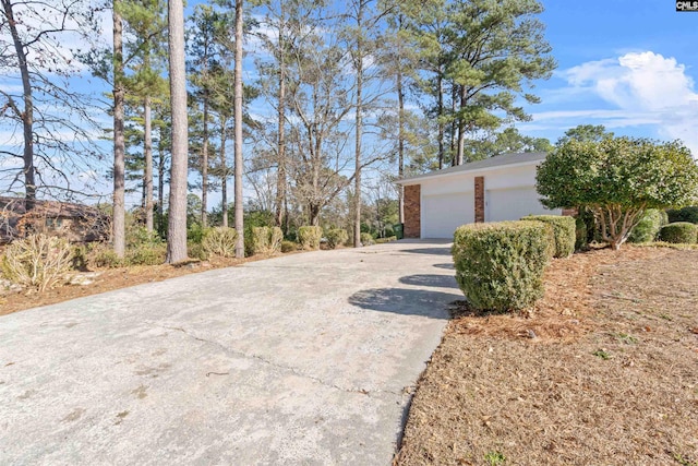 view of property exterior featuring a garage, an outbuilding, and brick siding