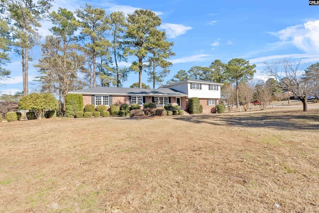 tri-level home featuring a front yard and brick siding