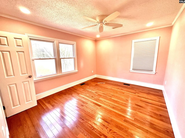 unfurnished room featuring ornamental molding, wood-type flooring, a ceiling fan, and baseboards