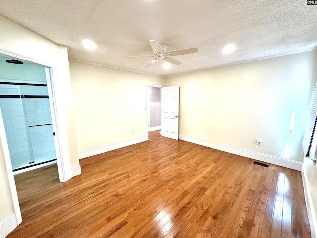 unfurnished bedroom with baseboards, light wood-style flooring, visible vents, and a textured ceiling