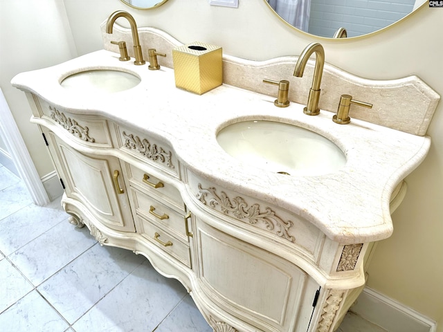 room details with double vanity, a sink, and baseboards