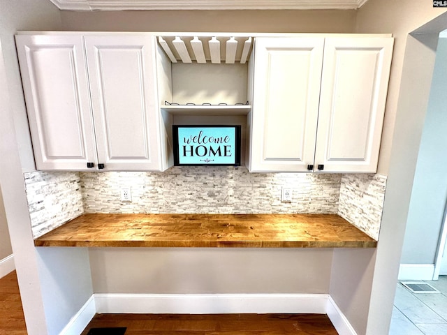 room details with backsplash, built in study area, visible vents, and baseboards