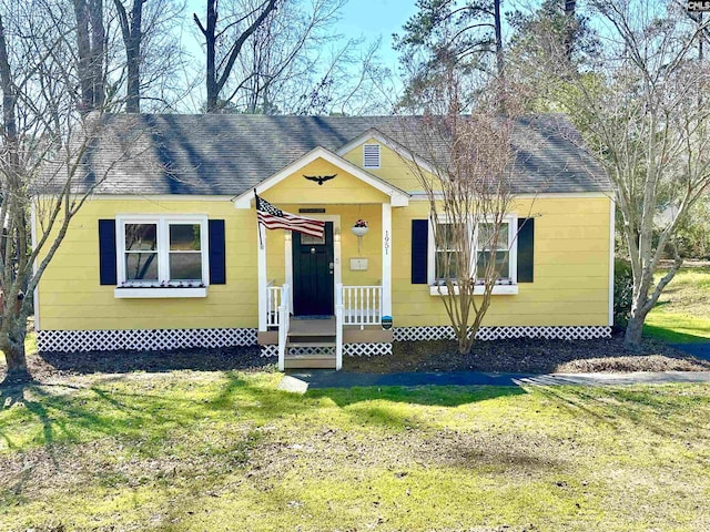 view of front of home featuring a shingled roof and a front yard