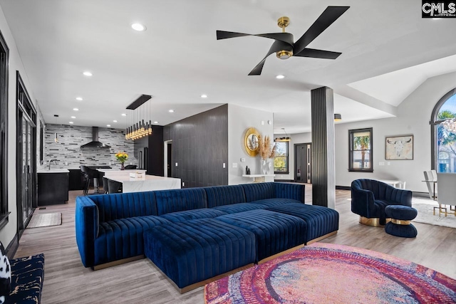 living area featuring ceiling fan, an accent wall, light wood-type flooring, and recessed lighting