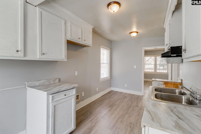 kitchen with exhaust hood, a sink, a wealth of natural light, and white cabinetry