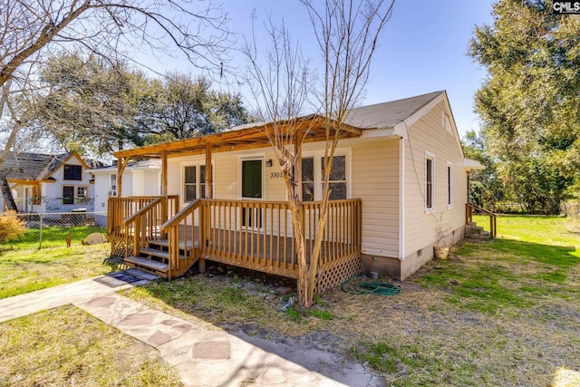 view of front of home featuring crawl space, fence, a front lawn, and a wooden deck