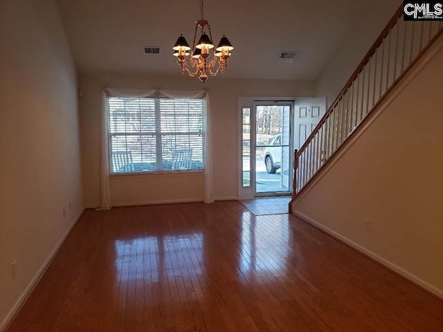 foyer entrance with visible vents, stairway, hardwood / wood-style flooring, and baseboards