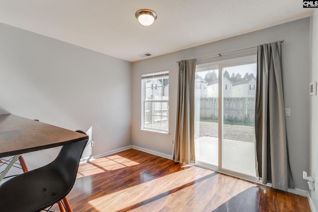 office area with visible vents, baseboards, and wood finished floors