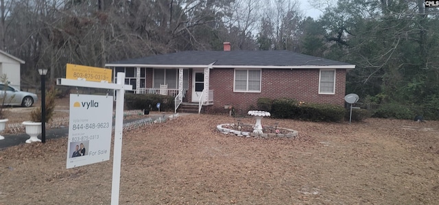 view of front of house with covered porch and brick siding