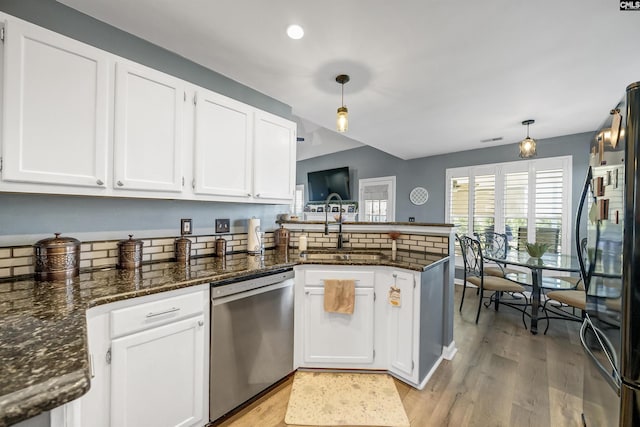 kitchen with white cabinets, dishwasher, freestanding refrigerator, a peninsula, and a sink