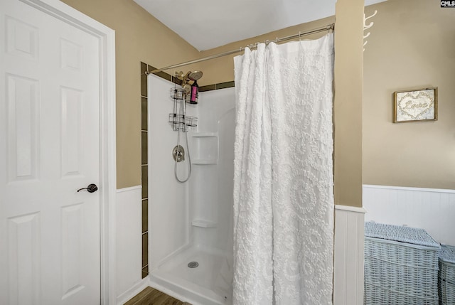 bathroom with curtained shower and wainscoting