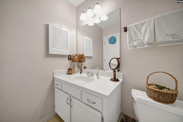 bathroom with vanity, toilet, and baseboards