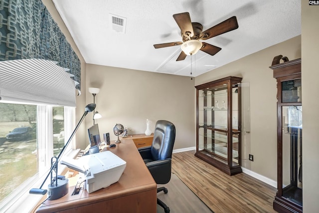 office area featuring ceiling fan, a textured ceiling, visible vents, and wood finished floors