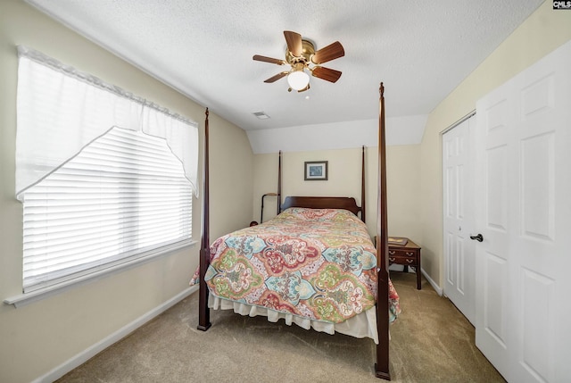 bedroom with visible vents, lofted ceiling, a textured ceiling, carpet floors, and a closet