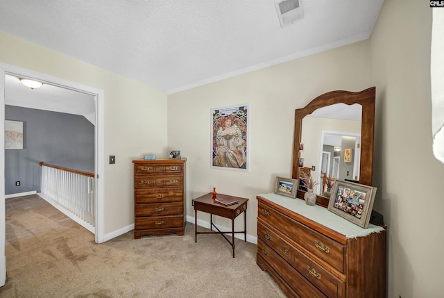 living area featuring light carpet, visible vents, baseboards, and a textured ceiling