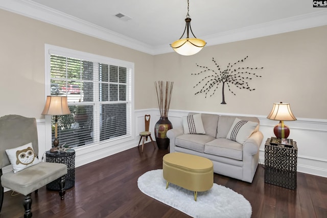 living area featuring wainscoting, wood finished floors, visible vents, and crown molding